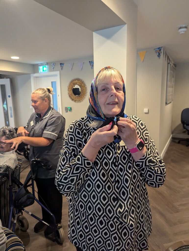 Jayne, Home Manager at St Mary's Chanterlands demonstrates a head scarf, a much-loved accessory of the 70s and part of the Marks and Spencer Memory Box!